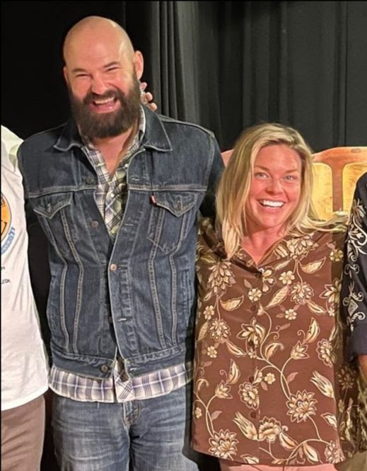 Jesse and Emily smiling in a kickline